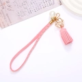 Portachiavi in camoscio rosa con borchie dorate, perle e ciondolo a nappa per borse - Rosa