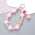 Détail d'un pendentif pour téléphone avec pompon rose et perles en forme de fraise - Charme de Pendentif Boule en Peluche Rose (K2667)