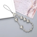Silver metallic heart beaded phone strap with Y2K aesthetic hanging on a decorative plate - Silver Plated Heart (K2908)