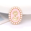 Close-up of cameo style brooch with golden female silhouette and faux pearl border - Pink Lady Portrait
