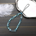 Details einer blauen Handy-Trageschlaufe mit Acrylherz und Marmorperlen auf Tablett - Blau