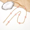 Detail of a gold crossbody chain with pink smiley faces and metal lobster clasps - Pink