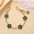 Detail of gold chain with green five-leaf flowers, heart pendant and white pearls - Green