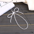 Elegant white beaded bowtie phone strap with pearls and clear beads on fabric background - White