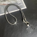 Detail of crossbody phone chain with rhinestone inlay and silver lobster clasp on dark texture - Gray