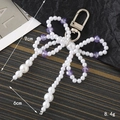 Pendentif nœud en perles et perles violettes avec mousqueton argenté pour sacs - Breloques / Violet