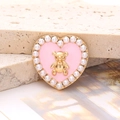 Vue macro d'un charme cœur rose avec relief d'ours doré et bordure en perles blanches - Cœur Ours Perle - Or Rose (D2639)