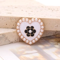 Macro detail of heart-shaped pearl brooch with camellia flower on stone background - Enamel Pearl Camellia - Gold Black (D2645)