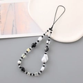 Modern mixed bead phone strap featuring baroque pearls and black beads on white display - Black
