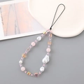 Elegant phone charm with baroque pearls and pink beads displayed on a ceramic plate - Pink