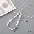 Beaded phone lanyard with pearls and silver heart charms on a textured grey background - 20cm Phone Chain / Irregular Pearl Heart