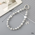 Beaded crystal keychain with silver bow and rose charms on a minimalist grey background - Charm / Flower Bow Beaded Pendant