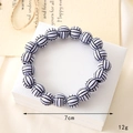 Detailed close-up of a white volleyball beaded bracelet on a beige gift box with card - Volleyball Beaded Bracelet