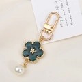 Detalle de llavero de flor con pétalos verdes y perla blanca sobre fondo de tela suave - Estilo Flor de Concha de Imitación (K3603) / Verde