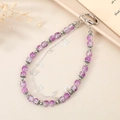 Portachiavi con perle viola e ciondolo a farfalla in argento su sfondo dai toni caldi - Stile Perline Viola Ghiaccio