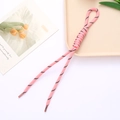 Detailaufnahme der pink-schwarzen geflochtenen Kordel mit Römerknoten und Endkappe - Koreanisches Rosa