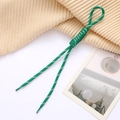 Detail of green and white woven spiral phone lanyard on a textured knit background - Green