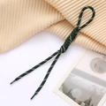 Close-up of dark green and white hand-woven paracord keychain with a classic Roman knot - Dark Green