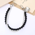 Detail view of double-strand pearl phone strap with silver heart charm and lobster clasps - Black and White Beaded Hand Chain Large Black Beads (K4268)