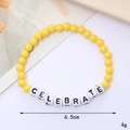 Detail showing colorful beaded bracelet with CELEBRATE letter beads and 6.5cm diameter scale - CELEBRATE Style (Yellow)