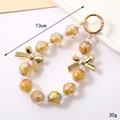 Iridized acrylic bead keychain with stars and bow charms, 13cm length, golden iridescent - Starry Sky Bead Pendant Gold