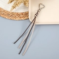 Détail d'un fermoir coeur en métal et de glands à monogramme pour sacs à main - Café