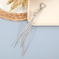 Détail du fermoir cœur en métal argenté avec pompon en corde tressée sur fond bleu - Kaki