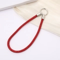 Detail of red rhinestone phone chain with a silver circular spring clasp and silk background - Red