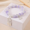 Lavender crystal bead bracelet with silver clouds and fan charms on a white jewelry box - Purple Fan Tassel Bracelet (K4238)
