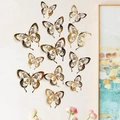 Details von 12 goldenen 3D-Hohl-Schmetterlings-Wandtattoos an einer beigen Wohnzimmerwand - Gold (LK07-Gold)