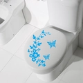 Adesivi blu con farfalle e fiori applicati su un coperchio bianco del WC per il bagno - Blu