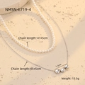Detail van zilveren hartjesketting en parelchoker op een stenen ondergrond met afmetingen - Parelketting en Harthanger Set (NMSN-E719-4)