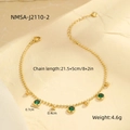 Detail of gold beaded anklet featuring emerald green gemstones on textured stone background - Green