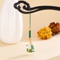 Detailed view of ceramic Maneki Neko charm with health tag on a green woven strap - Green Lucky Cat (K5898)