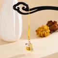 Close-up of ceramic lucky cat charm with Pingan gold tag and yellow braided cord - Yellow Lucky Cat (K5894)