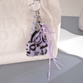 Plüschiger Taschenanhänger mit lila Leopardenmuster, Perlenkette und Schleife - Lila