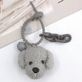 Dettaglio di un portachiavi a forma di cane in peluche grigio con cuore e campanello - Grigio Con Campanello