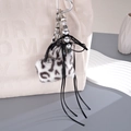 Dettaglio ravvicinato di un ciondolo per borsa in peluche leopardato con fiocco e perle - Ciondolo Borsa Leopardato (K5890) / Nero