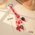 Dettaglio di ciondolo intrecciato rosso con perle in acrilico e moschettone argento - Quattro Fili Rosso (K5946)