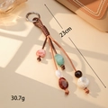 Dettaglio di ciondolo per borsa boho fatto a mano con perle colorate e corda intrecciata - Quattro Fili Marrone (K5944)
