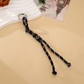 Detail shot of a handmade black and white woven paracord keychain with a silver spring clip - Black