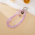 Detail of purple beaded phone strap with silver clover, pink heart and tassels - Purple
