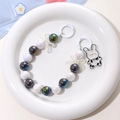 Detail of beaded bear keychain with iridescent pearls and cute rabbit pendant charm - Black + White