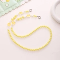 Detailed macro view of yellow acrylic beaded phone strap with cute heart and flower charms - K1199 Yellow
