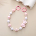Pink UV bear charm with beaded phone strap and spring ring clasp on beige background - Pink