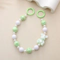 Detail showing a pastel green UV bear charm with marble beads and spring ring clips - Green