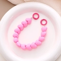 Macro detail of faceted pink heart beads and round spring buckles on phone strap - Rose Red