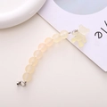 Nahaufnahme der gelben matten Perlen-Handykette mit Bärenanhänger und silbernem Verschluss - Bären-Charm-Stil / Champagner Armband