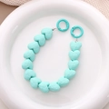 Detail of mint green heart-shaped faceted beads on a mobile chain with spring rings - Green