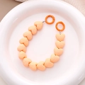 Detail of warm orange faceted heart beads on a chain with round spring buckles - Orange